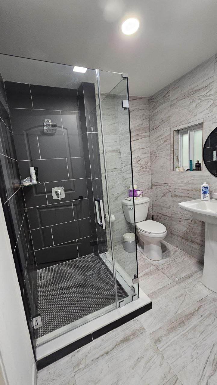 Black and white marble bathroom with frameless glass