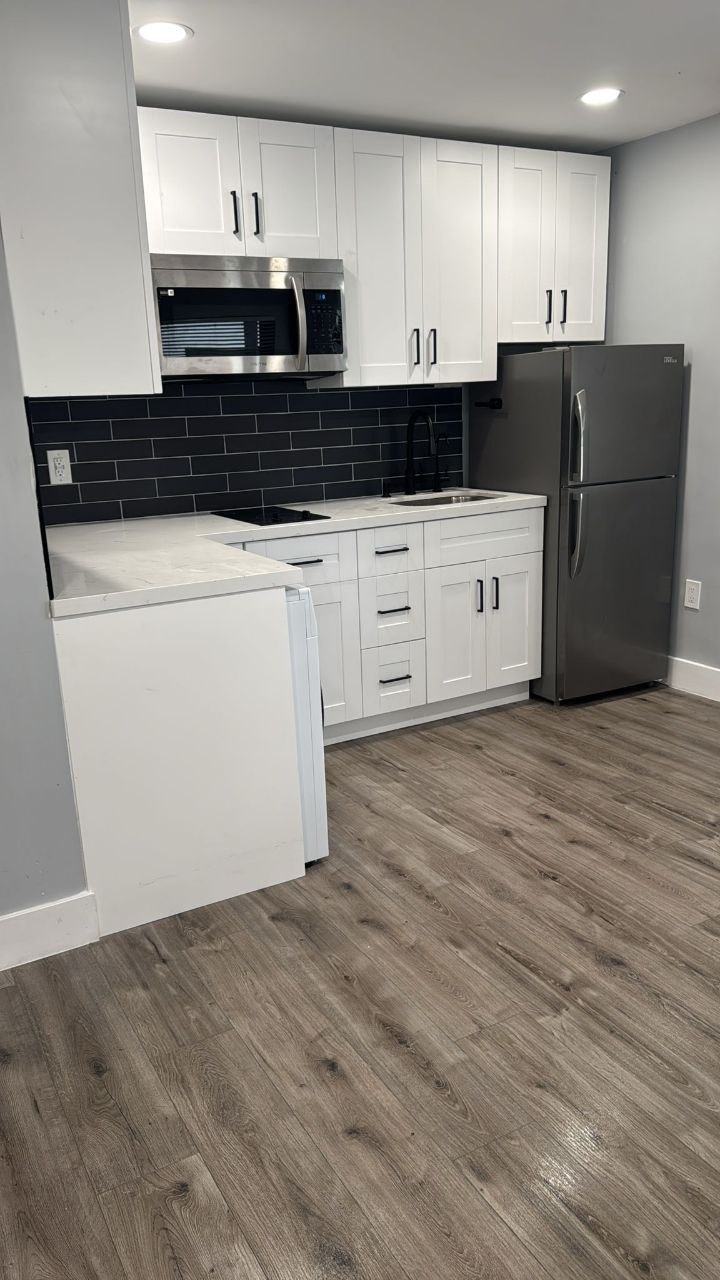 White shaker cabinets with black subway tile