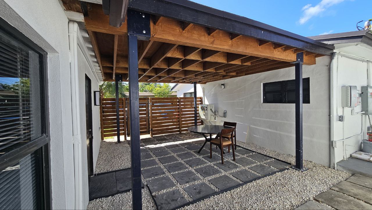 Covered steel pergola with outdoor furniture
